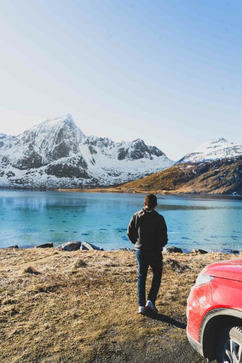 mehdi au bord de l'eau turquoise dans les lofoten