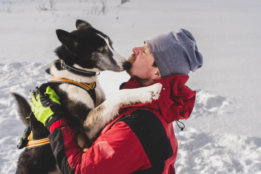 tommy de team lyngen qui fait un câlin à son chien